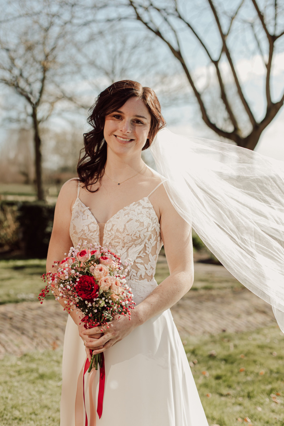 een vrouw in een trouwjurk die een boeket bloemen vasthoudt