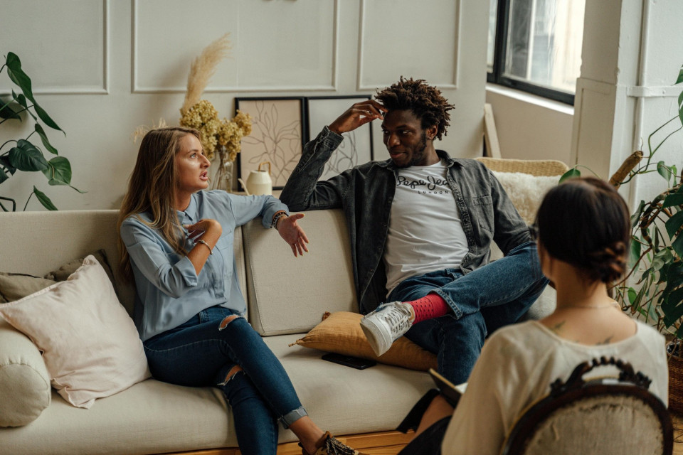 een man en een vrouw die op een bank in een woonkamer zitten