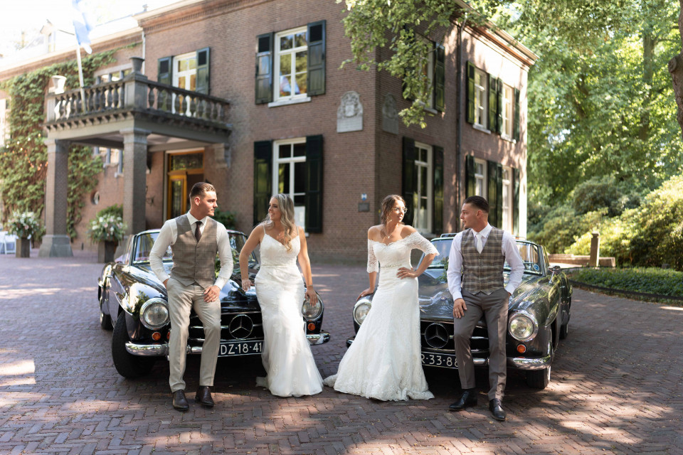 een bruid en bruidegom poseren met hun klassieke auto's