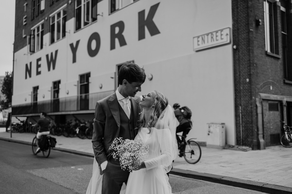 een bruid en bruidegom poseren voor een foto voor het New York bord