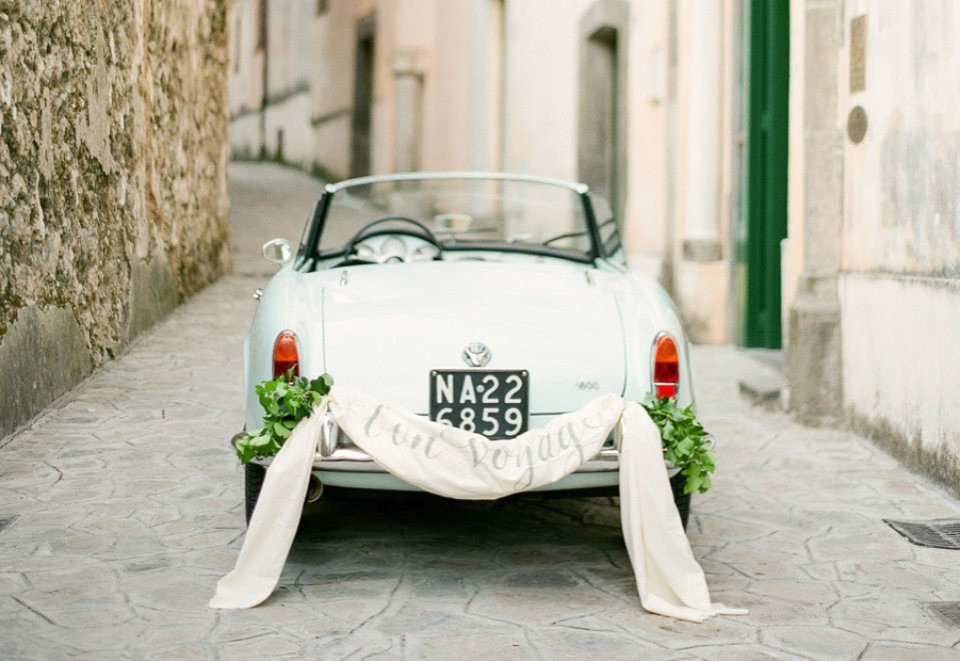 een vintage auto met een bord waarop staat 'trouwauto'