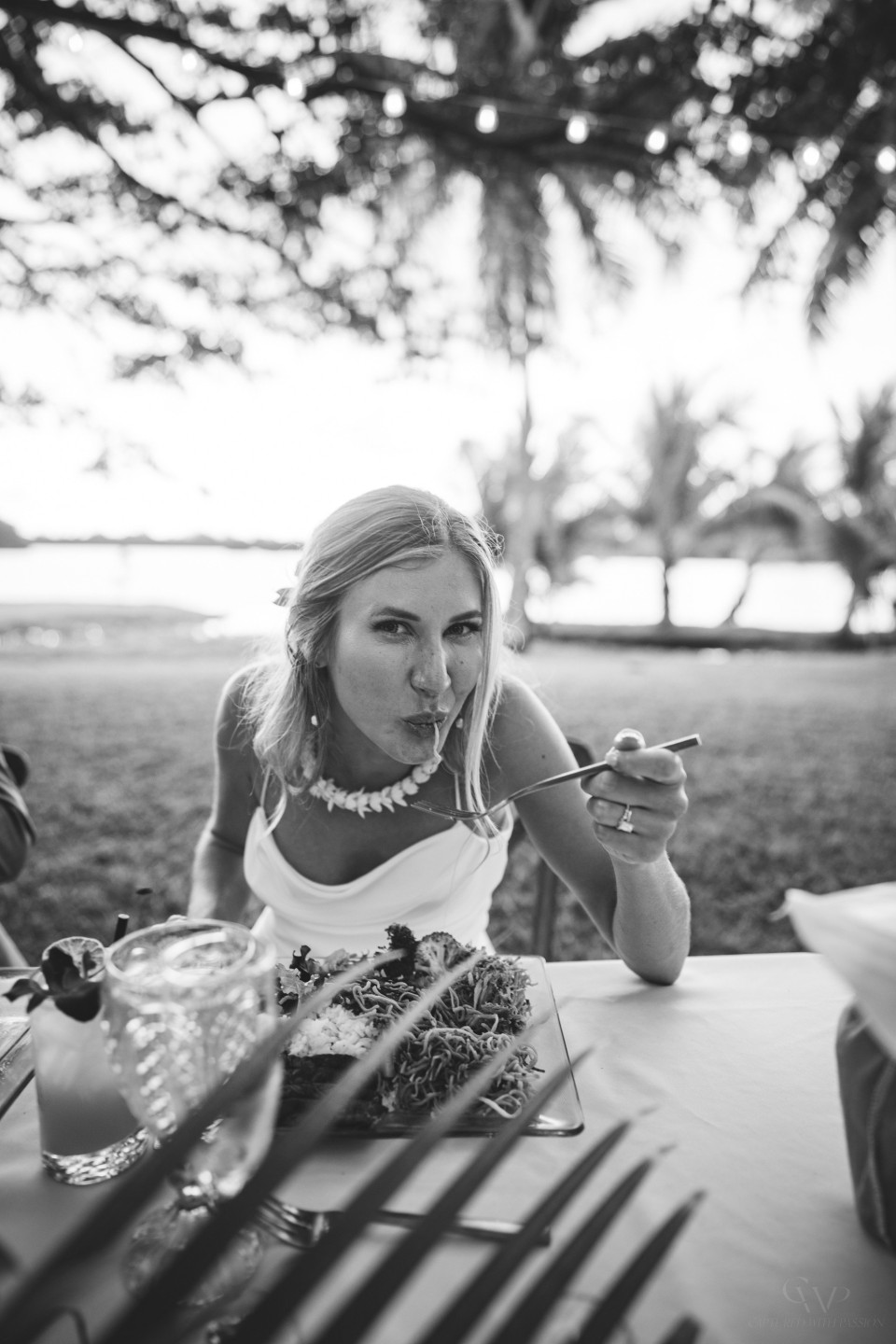 een vrouw die een salade eet aan een tafel met uitzicht op de oceaan