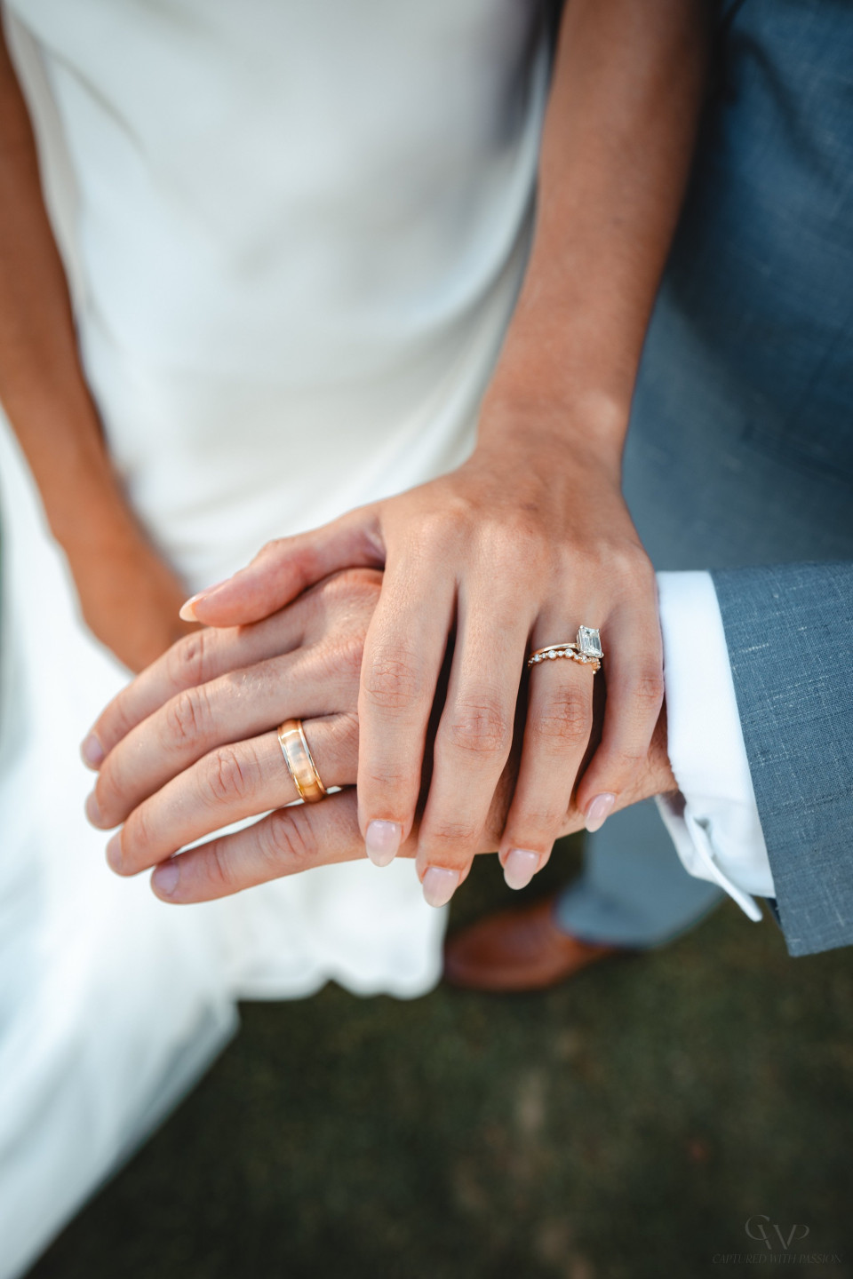 een bruid en bruidegom houden elkaars handen vast met trouwringen