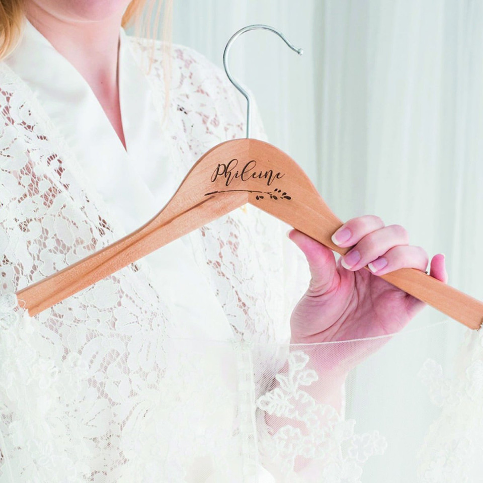 Hölzerner Kleiderbügel mit Zweigen und Namen