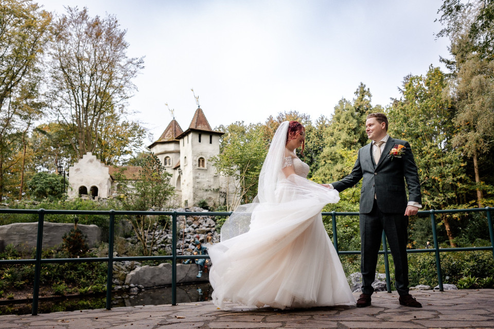 een bruid en bruidegom staan voor een kasteel