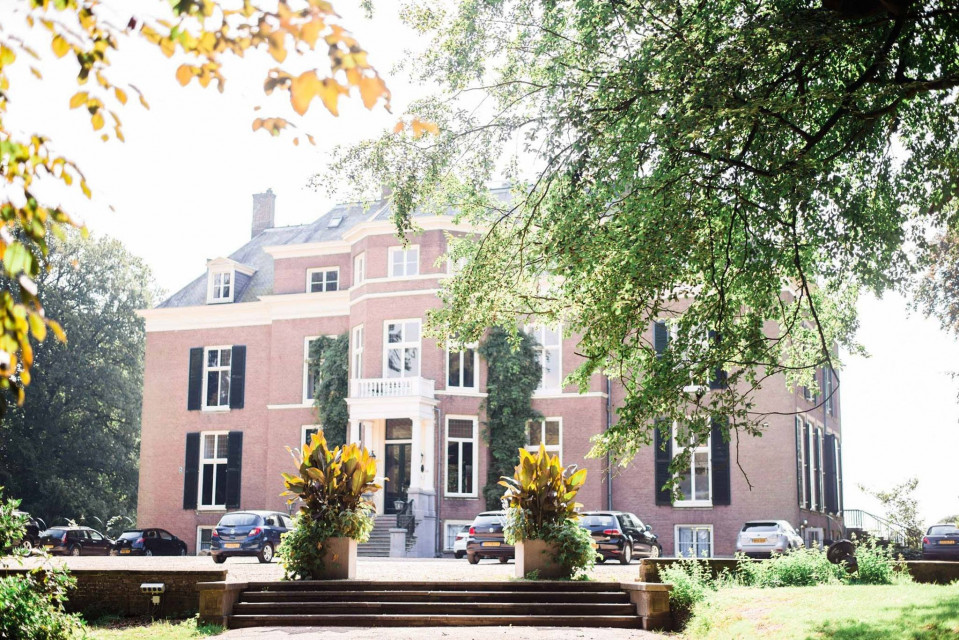 een groot landhuis met een grote voortuin