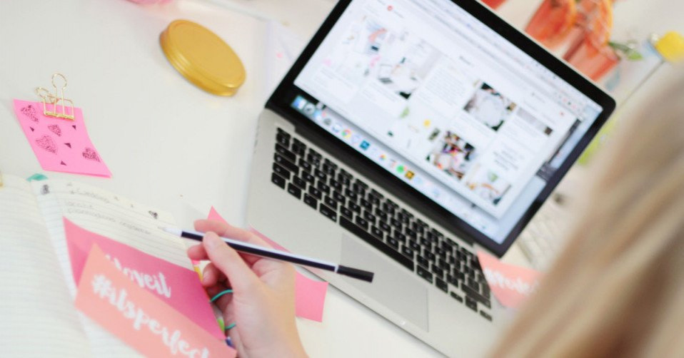 een vrouw werkt op haar laptop terwijl ze aan een bureau zit