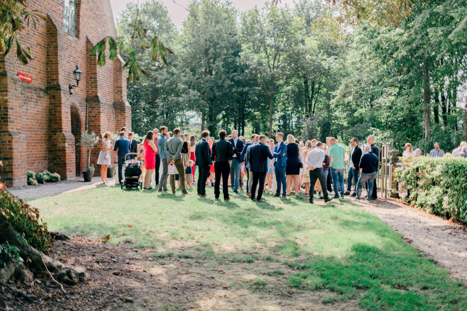 een bruiloftsfeest dat buiten een kerk staat