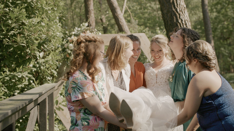 een bruid en haar bruidsmeisjes staan op een brug