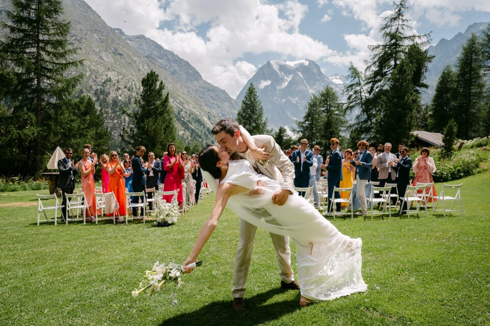 een bruid en bruidegom die kussen voor een menigte mensen