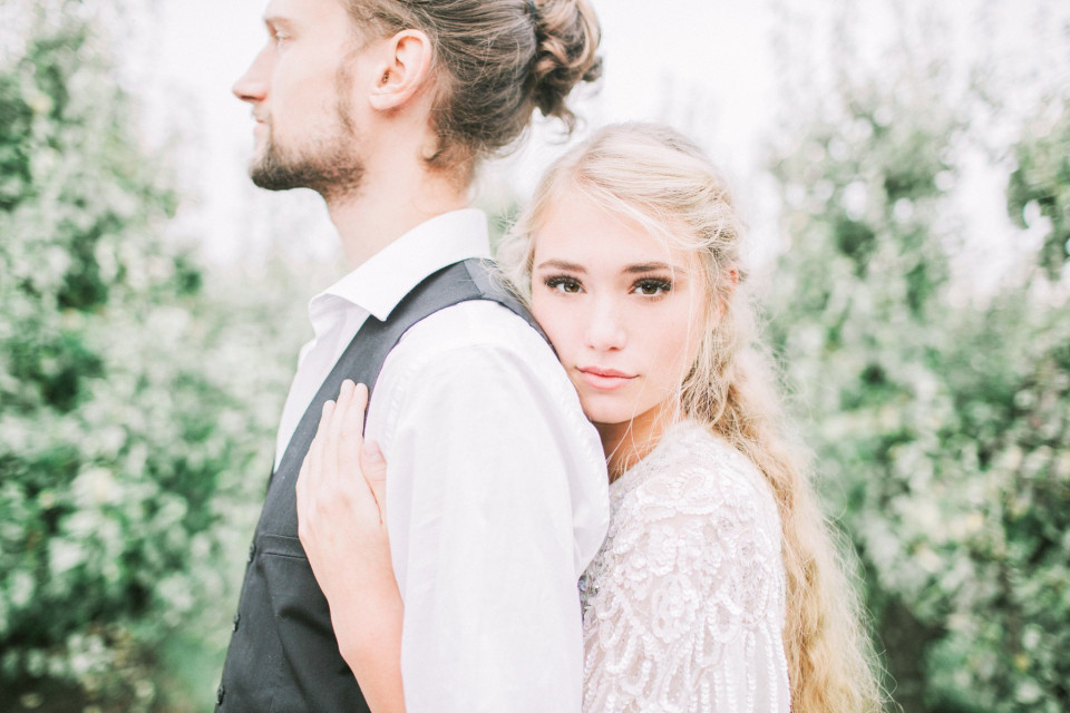 een mooi bruidspaar in een appelboomgaard