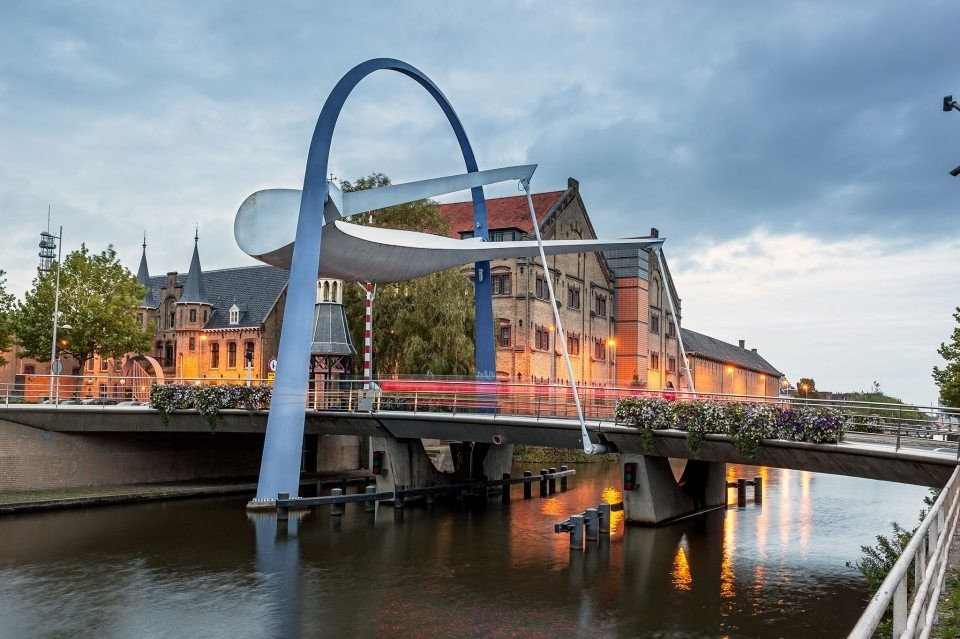 een brug over een rivier met een sculptuur in het midden