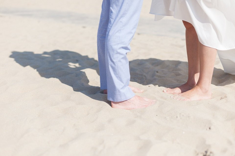 een bruid en bruidegom staand op het strand