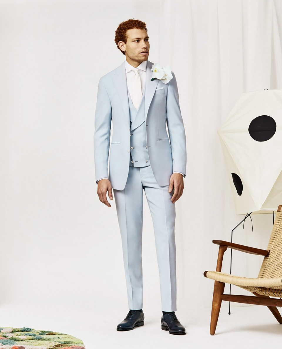 een man in een lichtblauw pak en stropdas