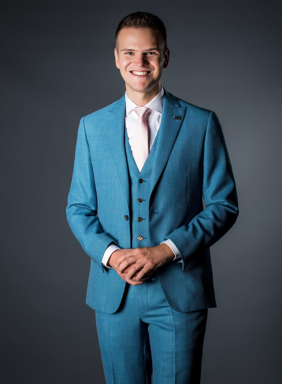 een man in een blauw pak die poseert voor de camera