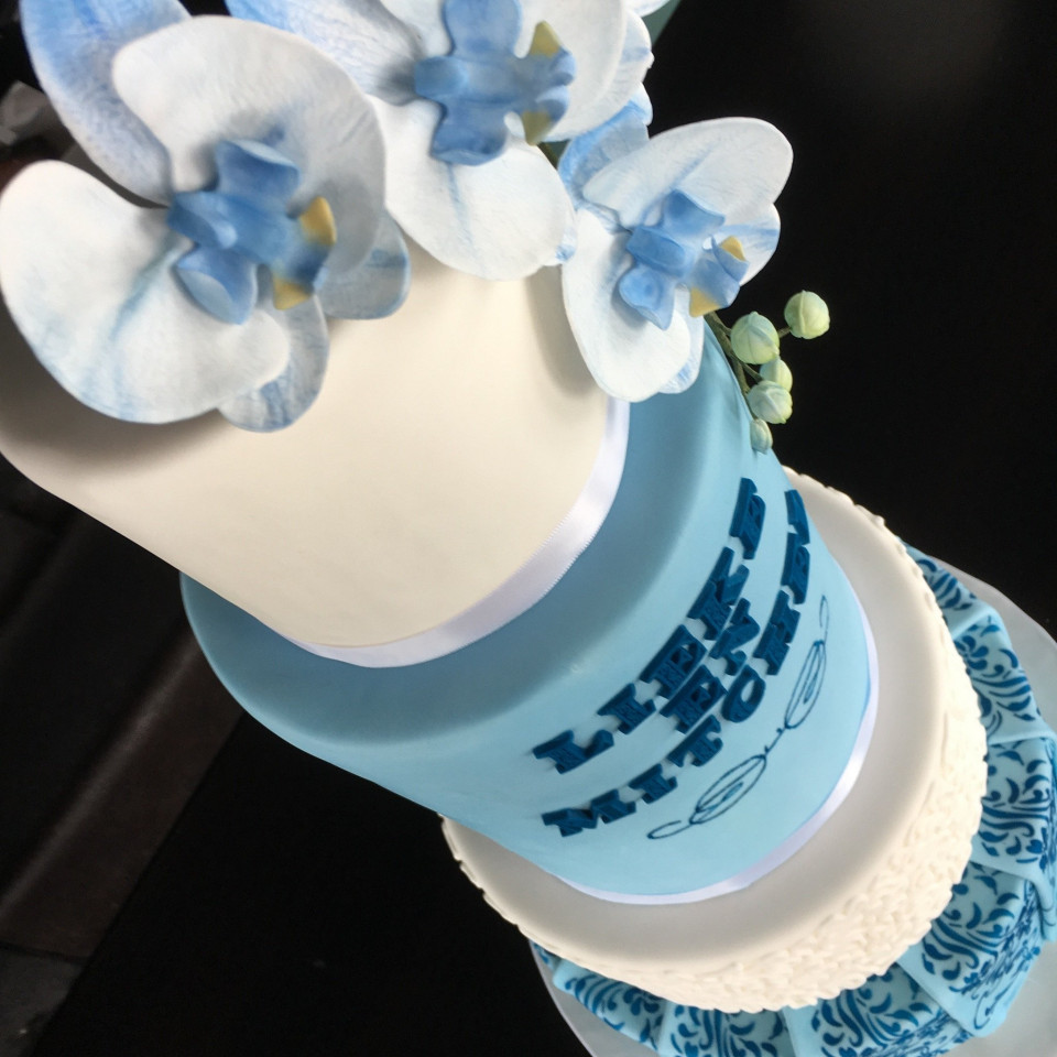 een blauwe en witte taart met bloemen erop