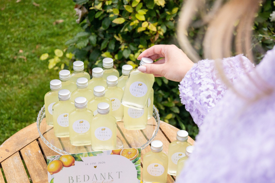 een persoon die een fles limonade op een tafel vasthoudt