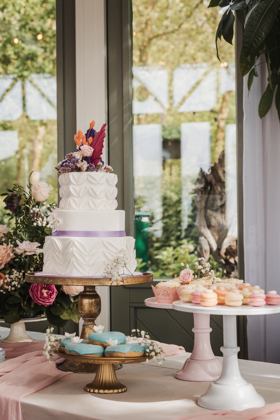 een bruidstaart en cupcakes op een tafel