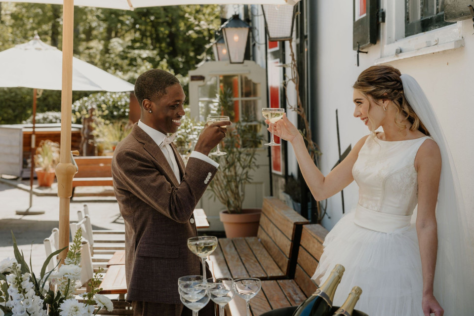 een afbeelding van een bruid en bruidegom die op elkaar toosten