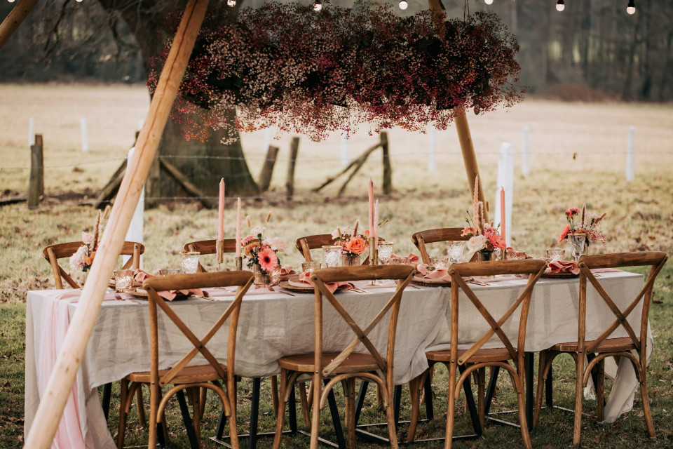 een rustieke buiten bruiloft tafelopstelling met stoelen en bloemen