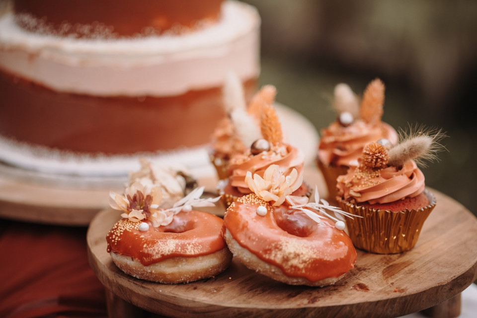 een taart met glazuur en donuts op een houten dienblad