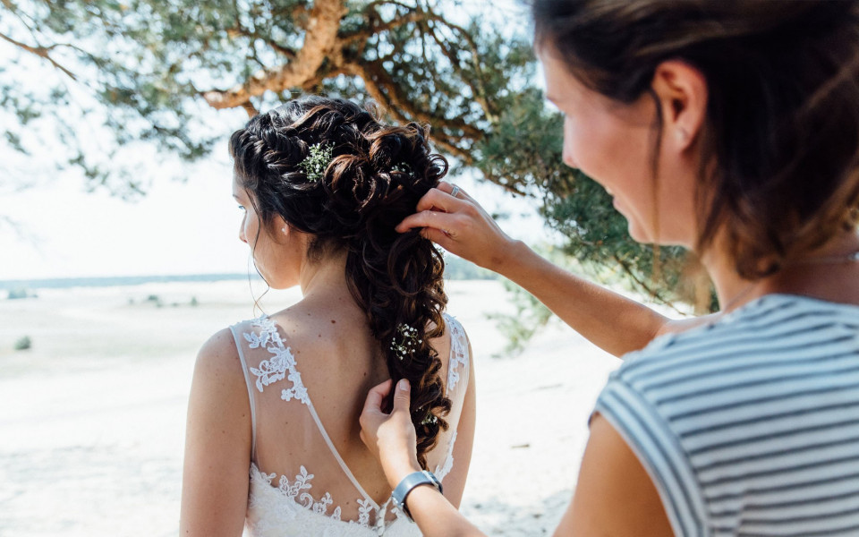 een bruid die haar haar laat doen door een kapper