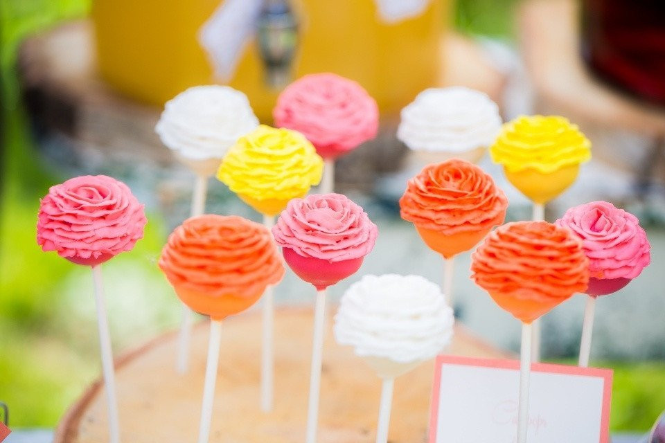 kleurrijke cake pops op een tafel met een bord