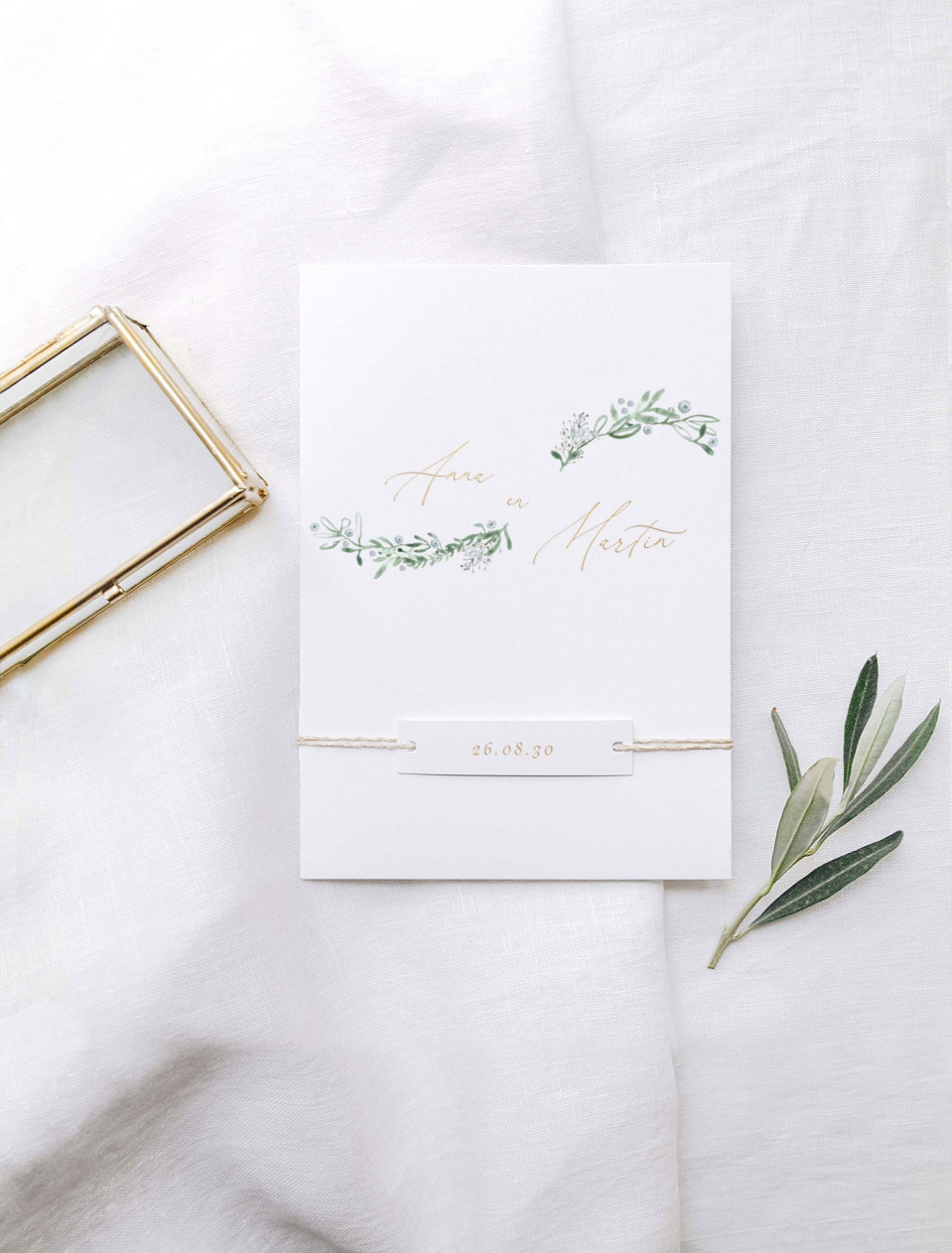 trouwuitnodiging met eucalyptusbladeren en gouden folie