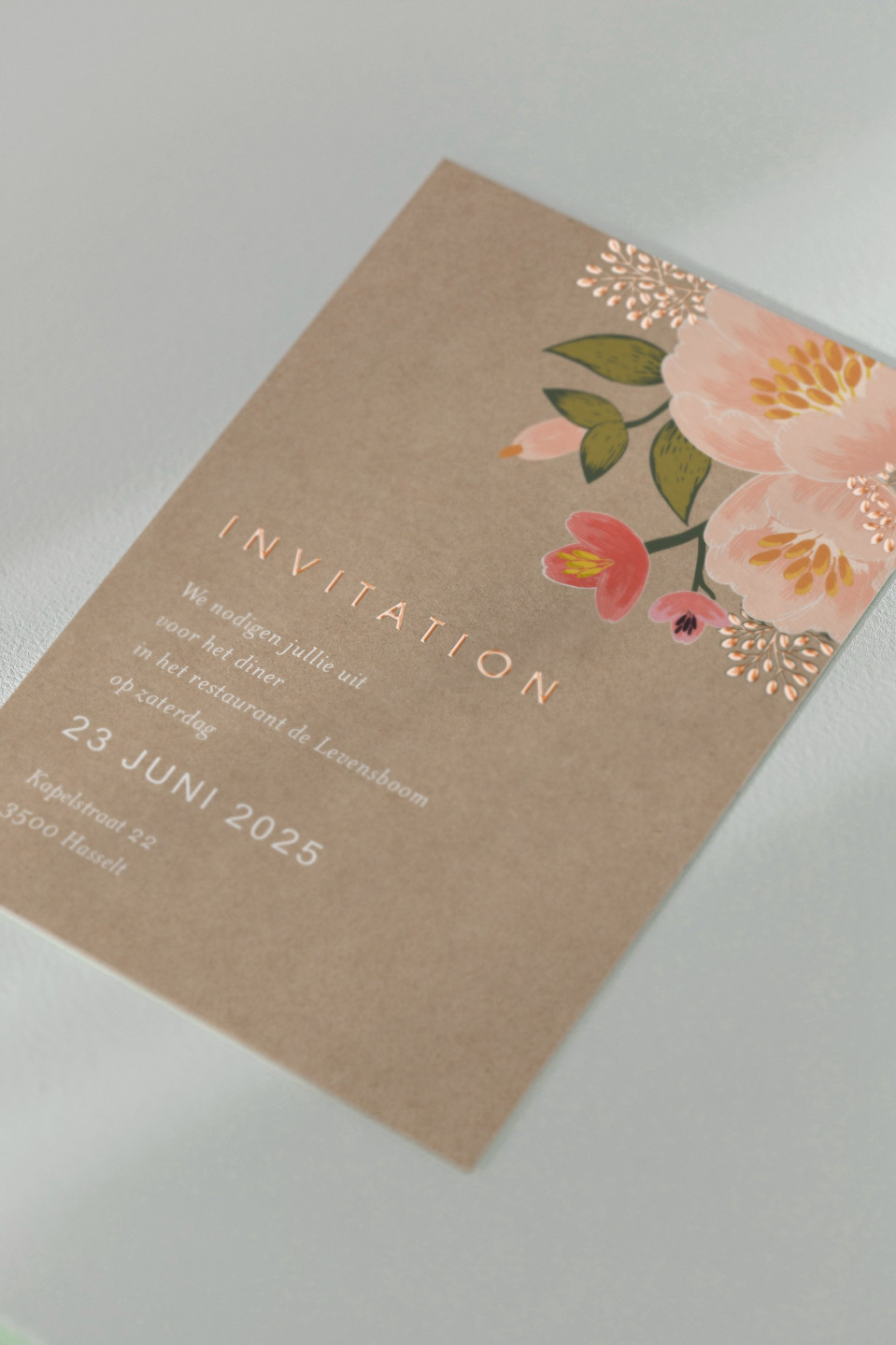 een trouwuitnodiging met bloemendesign erop