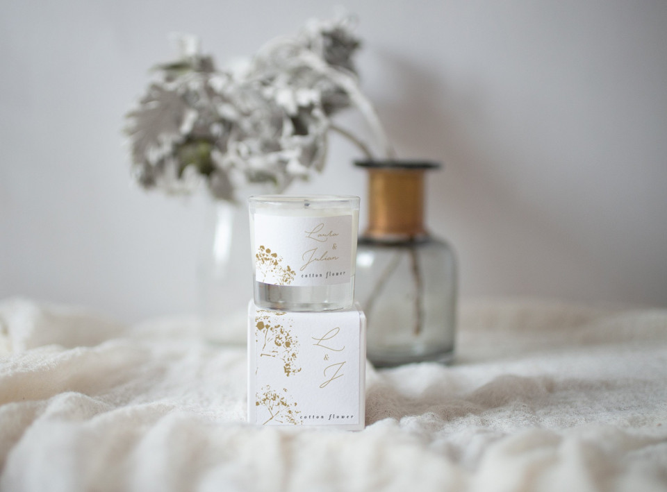 een kaars op een witte deken met bloemen
