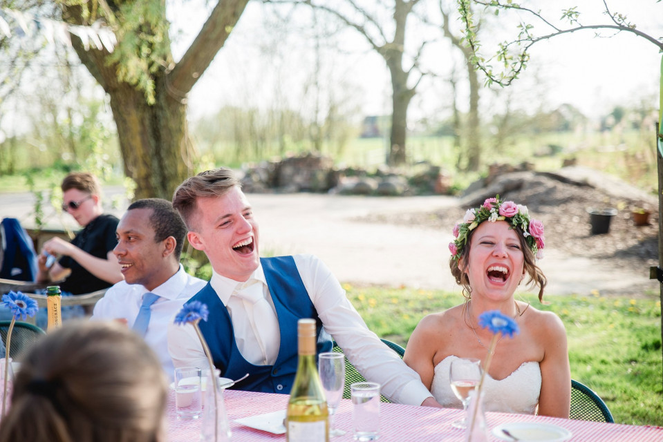 een bruid en bruidegom die lachen tijdens een bruiloftsreceptie