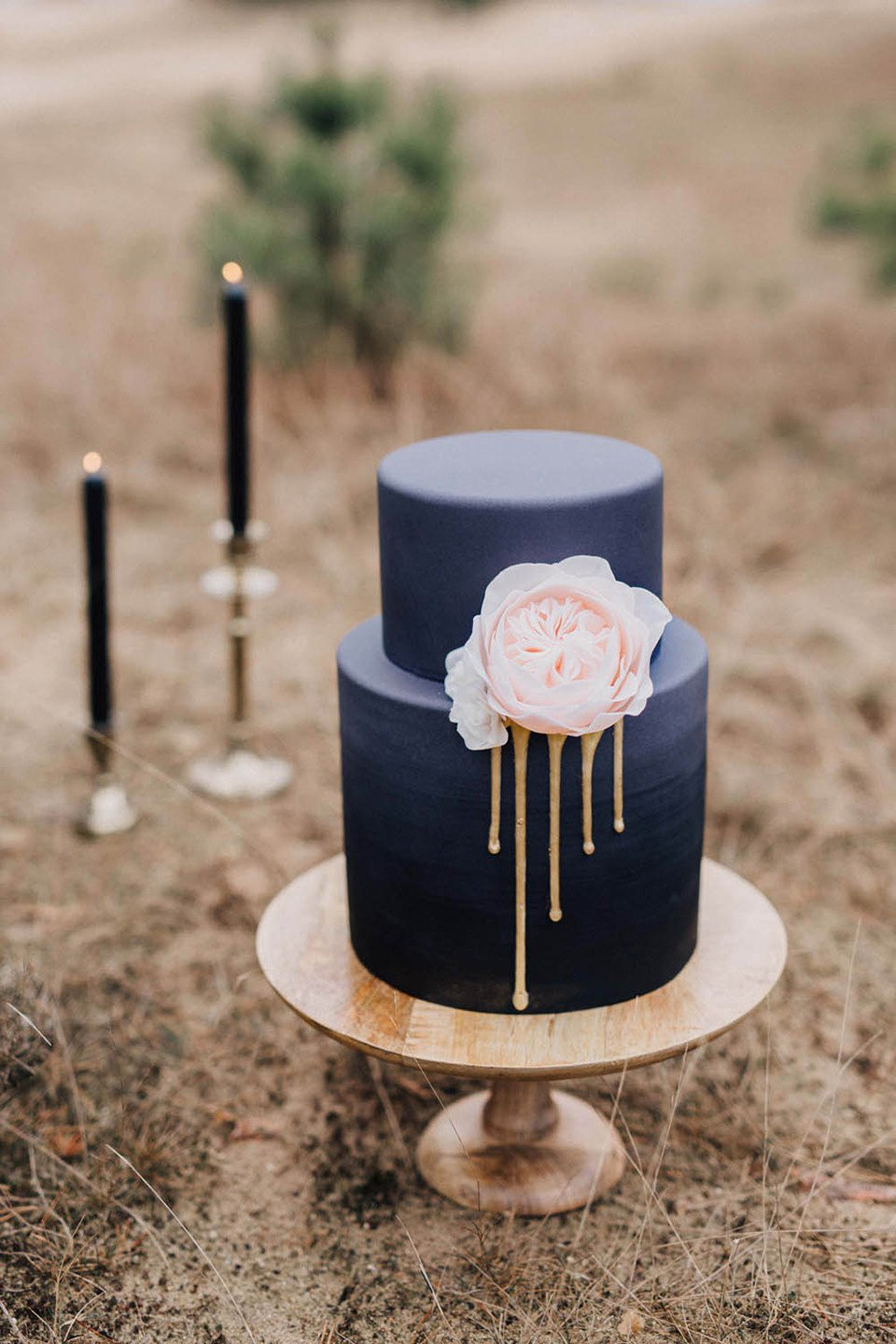 een zwart en gouden bruidstaart met een gouden druip