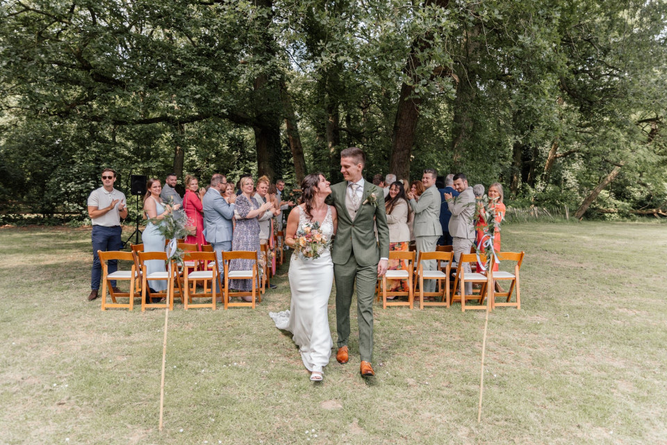 een bruid en bruidegom lopen het pad af voor hun gasten