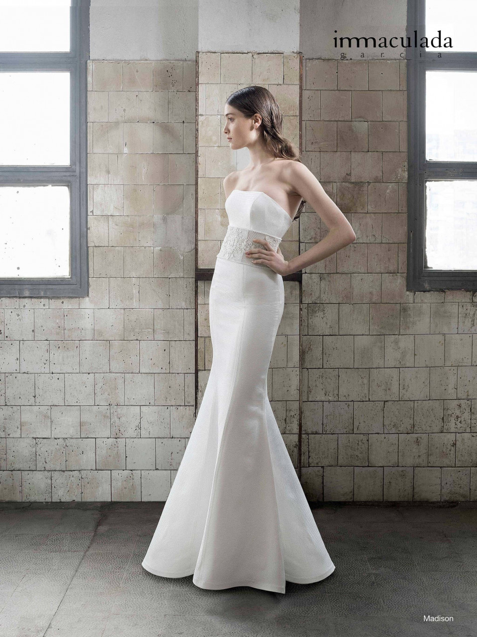 een vrouw in een strapless trouwjurk staande in een kamer