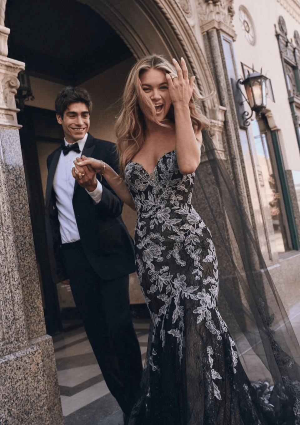 een vrouw in een zwarte jurk en een man in een smoking