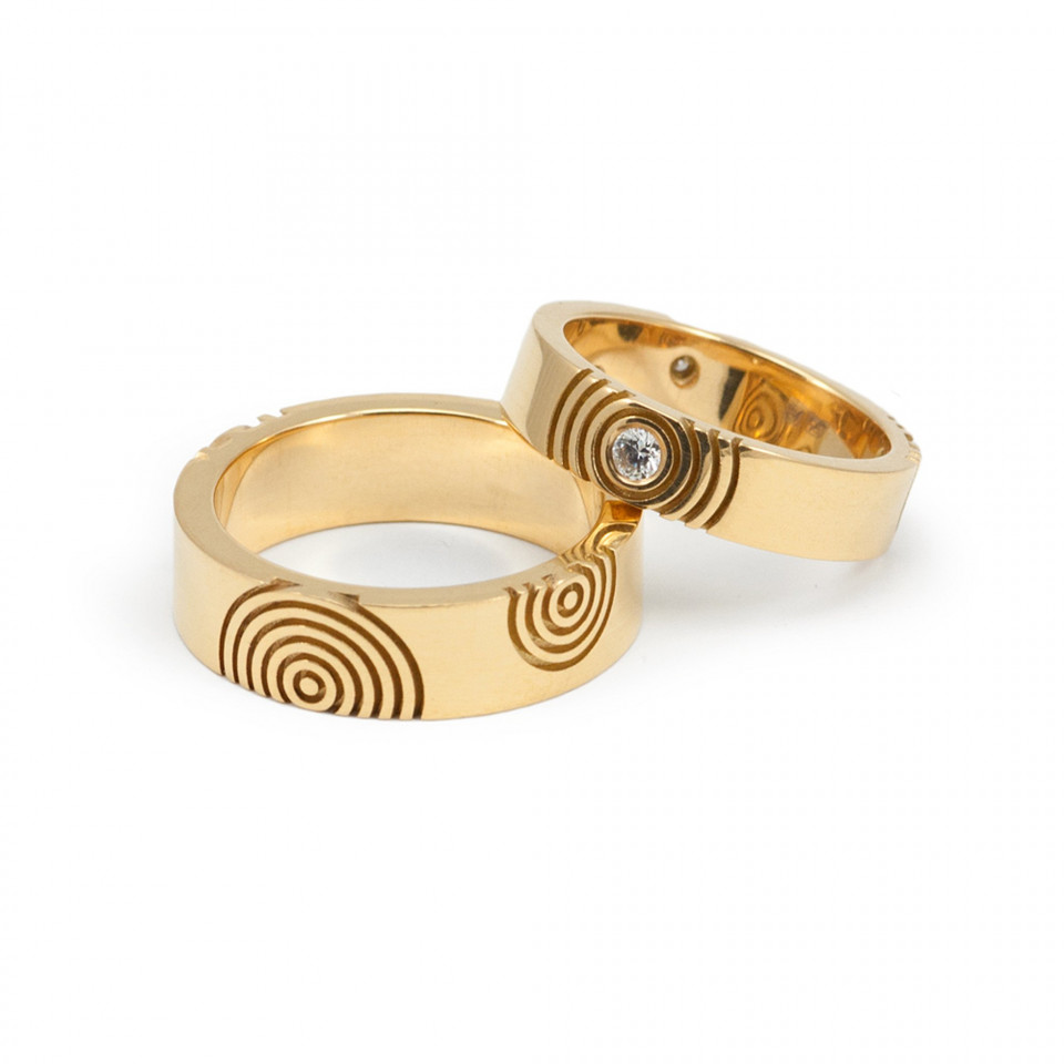twee gouden trouwringen met wervelende ontwerpen