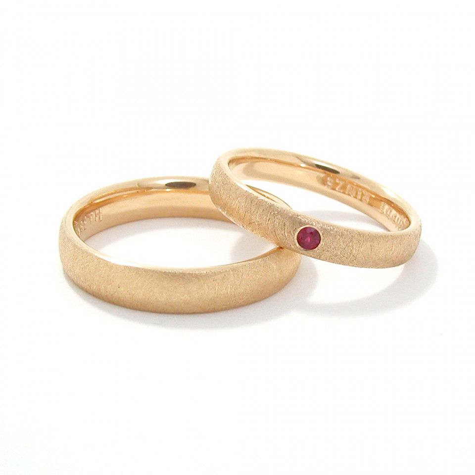 twee trouwringen met robijnstenen erop