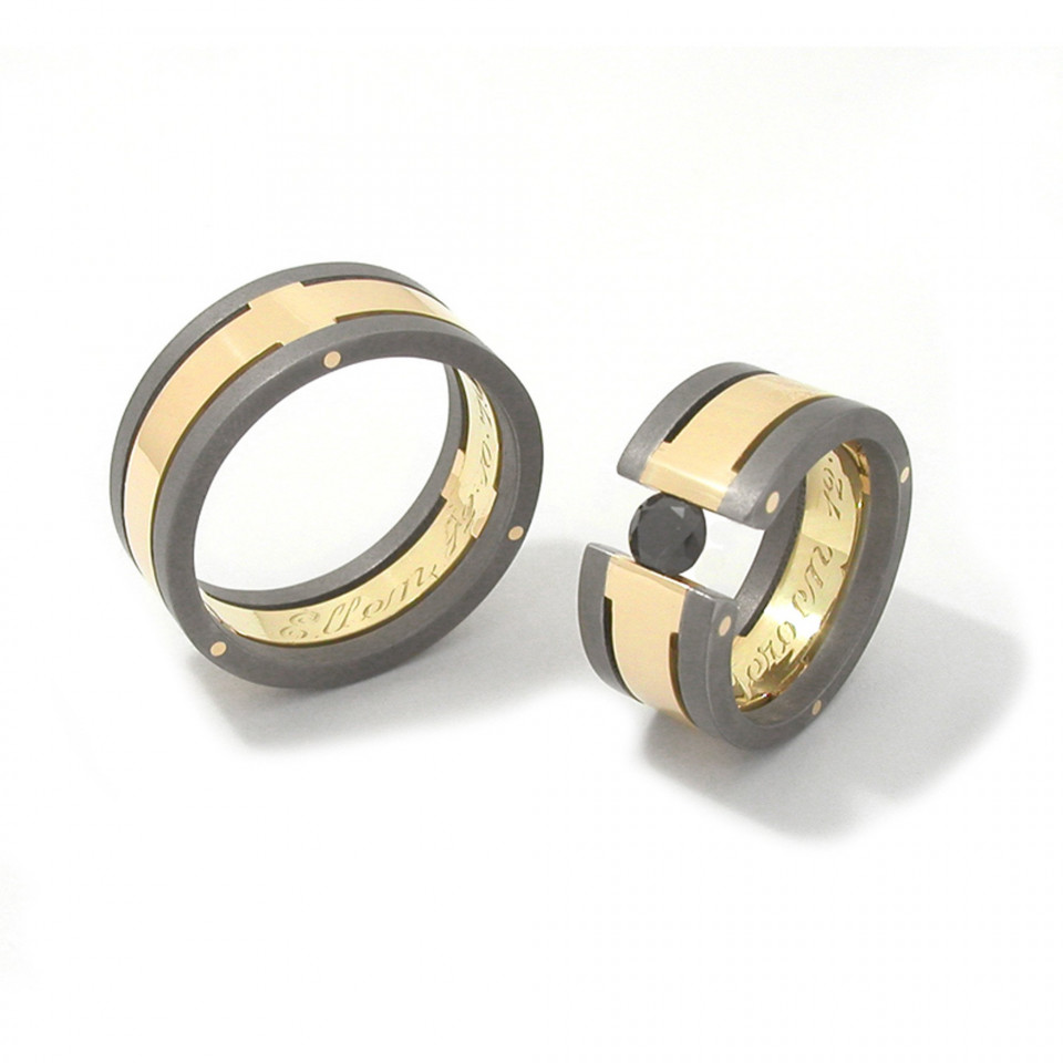 twee trouwringen met gouden en zwarte inleg