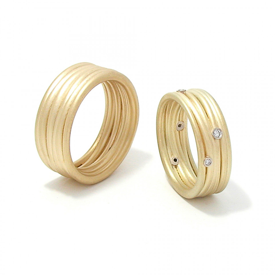 twee gouden ringen met diamanten erop