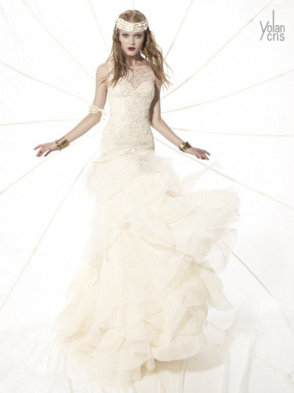 een vrouw in een trouwjurk poseert op een witte achtergrond