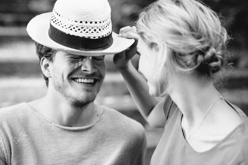 een man en vrouw glimlachen terwijl ze hoeden dragen