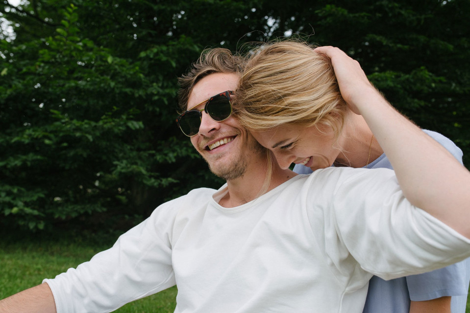 een man en vrouw zitten op een bank in het park