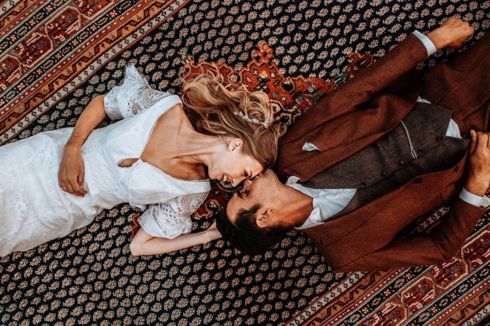 bruid en bruidegom liggen op een kleed