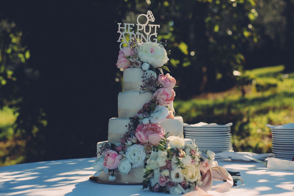 een bruidstaart met bloemen erop