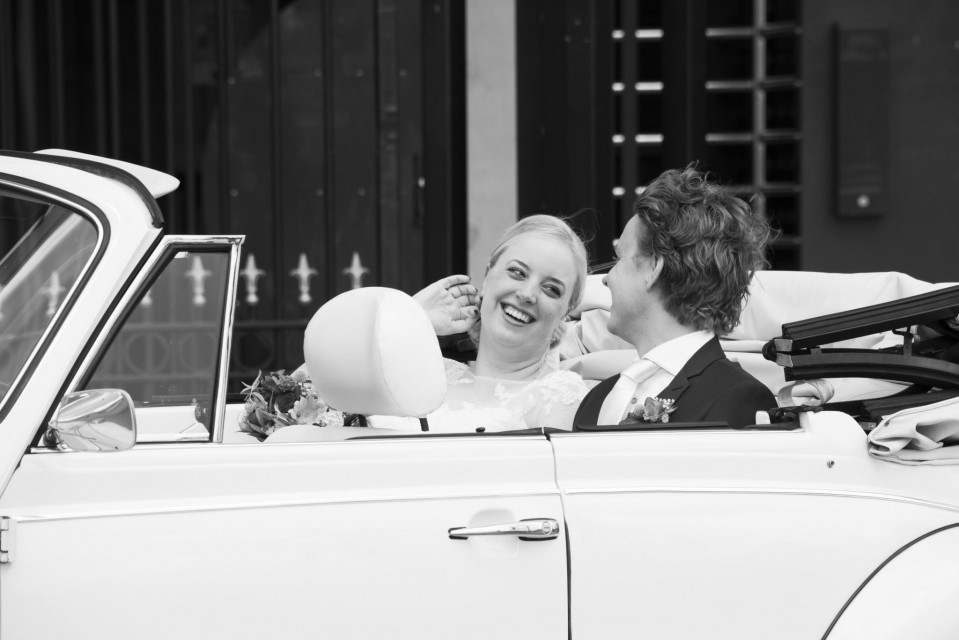 een bruid en bruidegom in een cabriolet