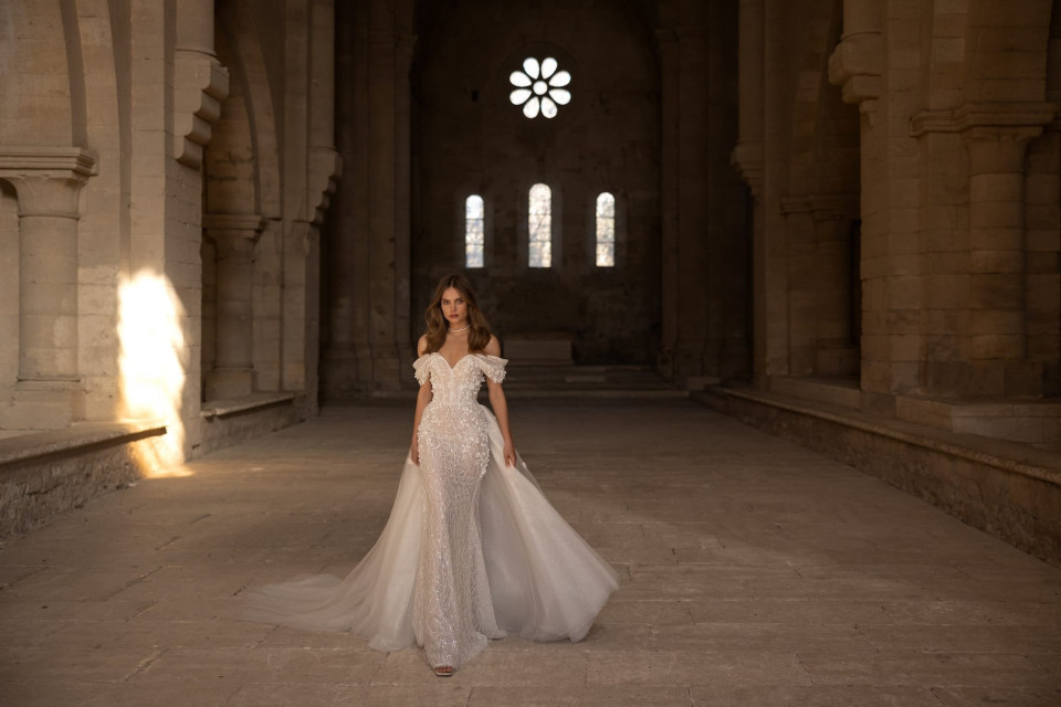 een bruid in een witte trouwjurk die in een lege kerk staat