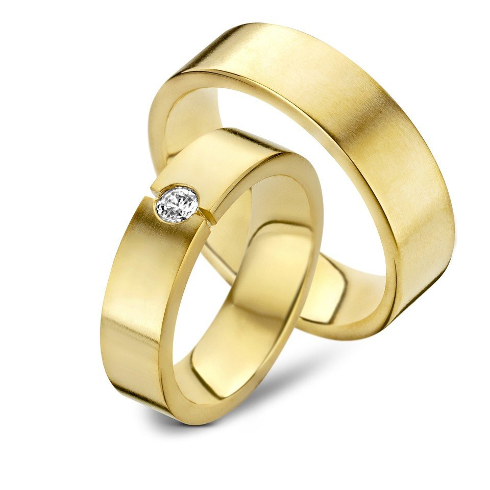 twee geelgouden trouwringen met een diamant