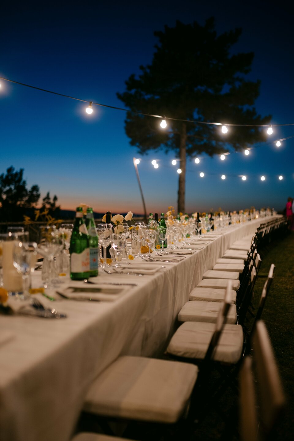een lange tafel die is gedekt voor een huwelijksfeest