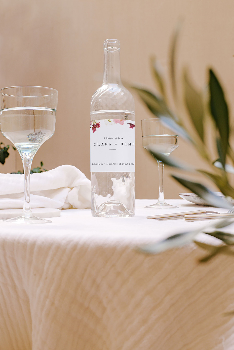 een tafel met een fles wijn en glazen erop