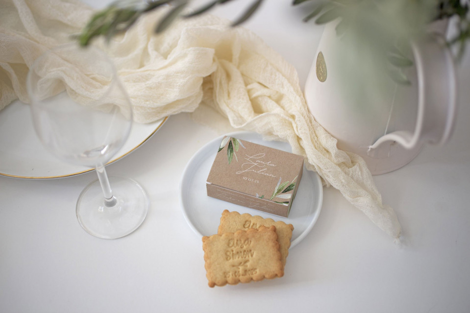 een bord met een glas wijn en een koekje